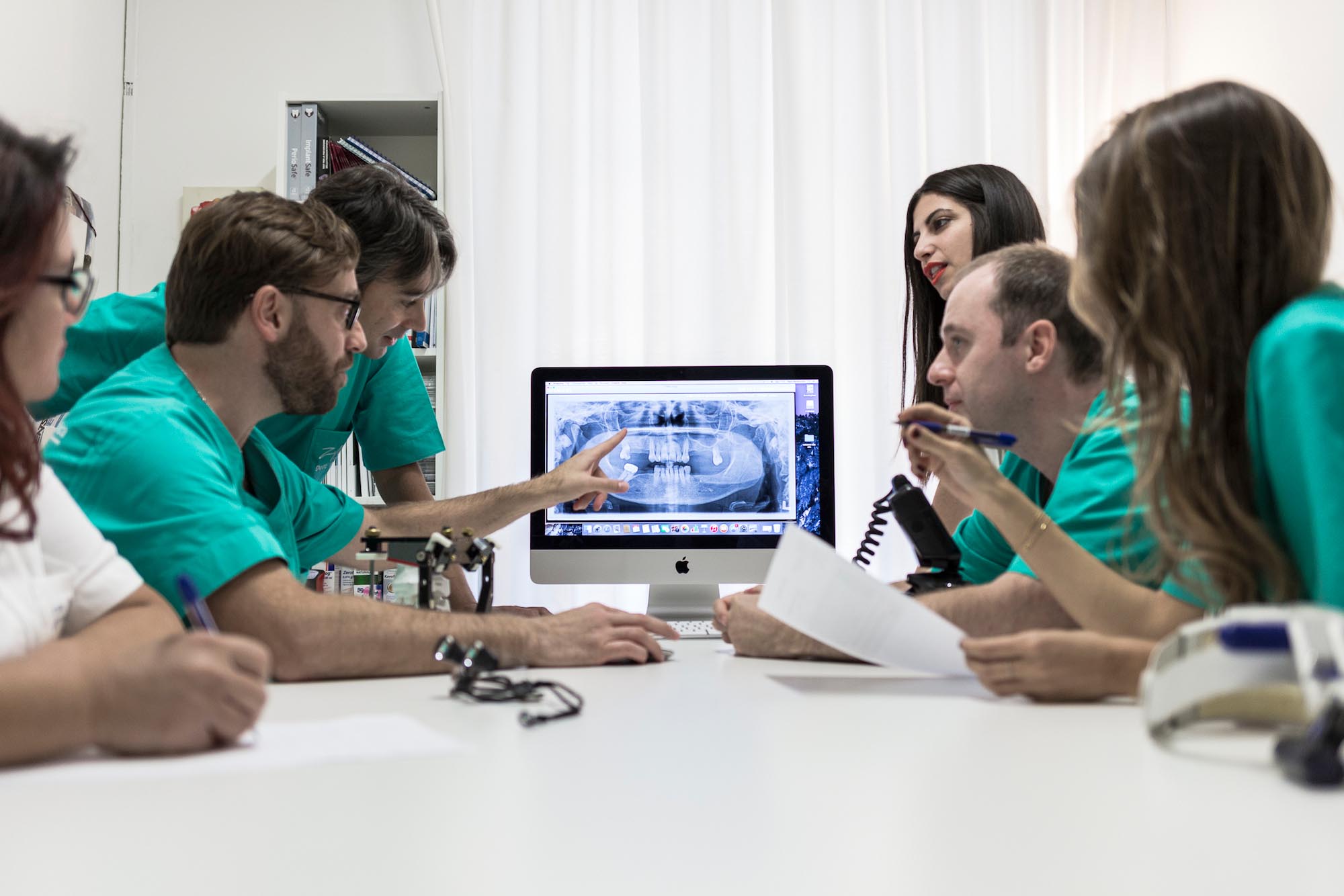 Il team dello studio riunito davanti a una radiografia panoramica